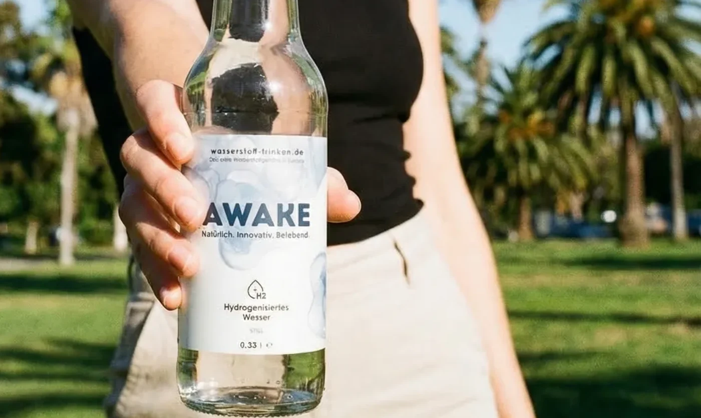 Water being poured from an AWAKE glass bottle