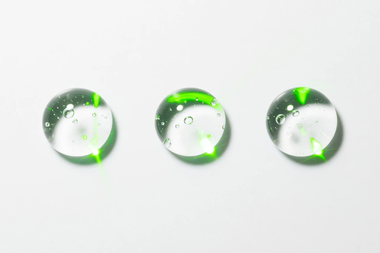 Three clear droplets with fine bubbles on a white background.