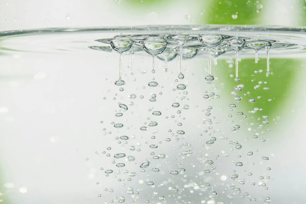 Rising microbubbles below a bright water surface.